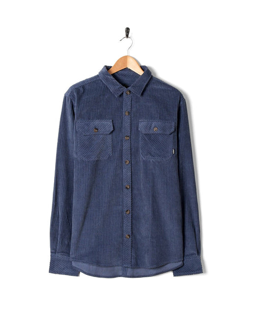 An Ace - Mens Long Sleeve Shirt - Blue with front chest pockets hanging on a hanger. Brand Name: Saltrock.
