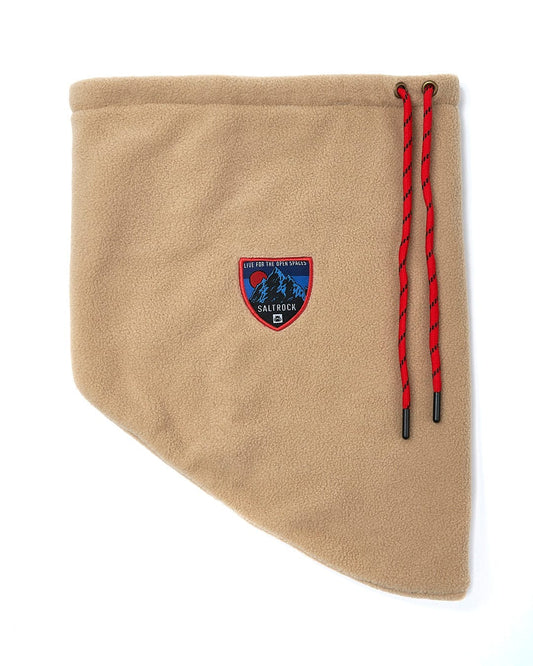 A Patchy - Borg Snood - Beige with a red ribbon tied around it.