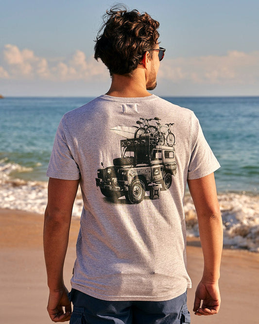A man wearing a Saltrock All Terrain - Men's Short Sleeve T-Shirt - Grey looking at the ocean.