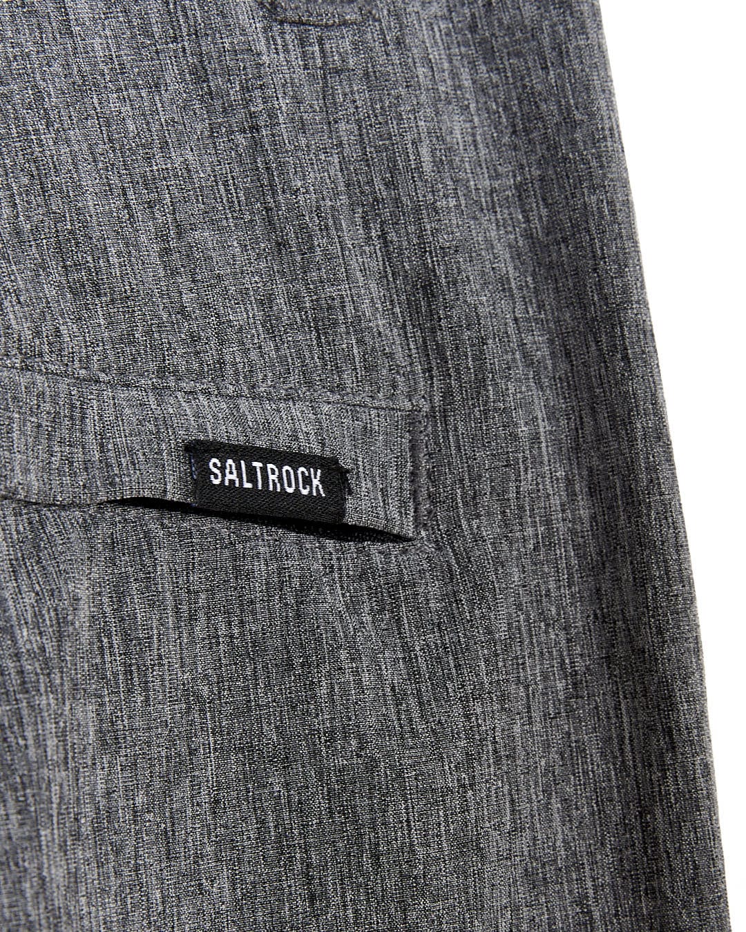 A close up of a Saltrock Amphibian - Kids Boardshorts - Grey with a black label on it.