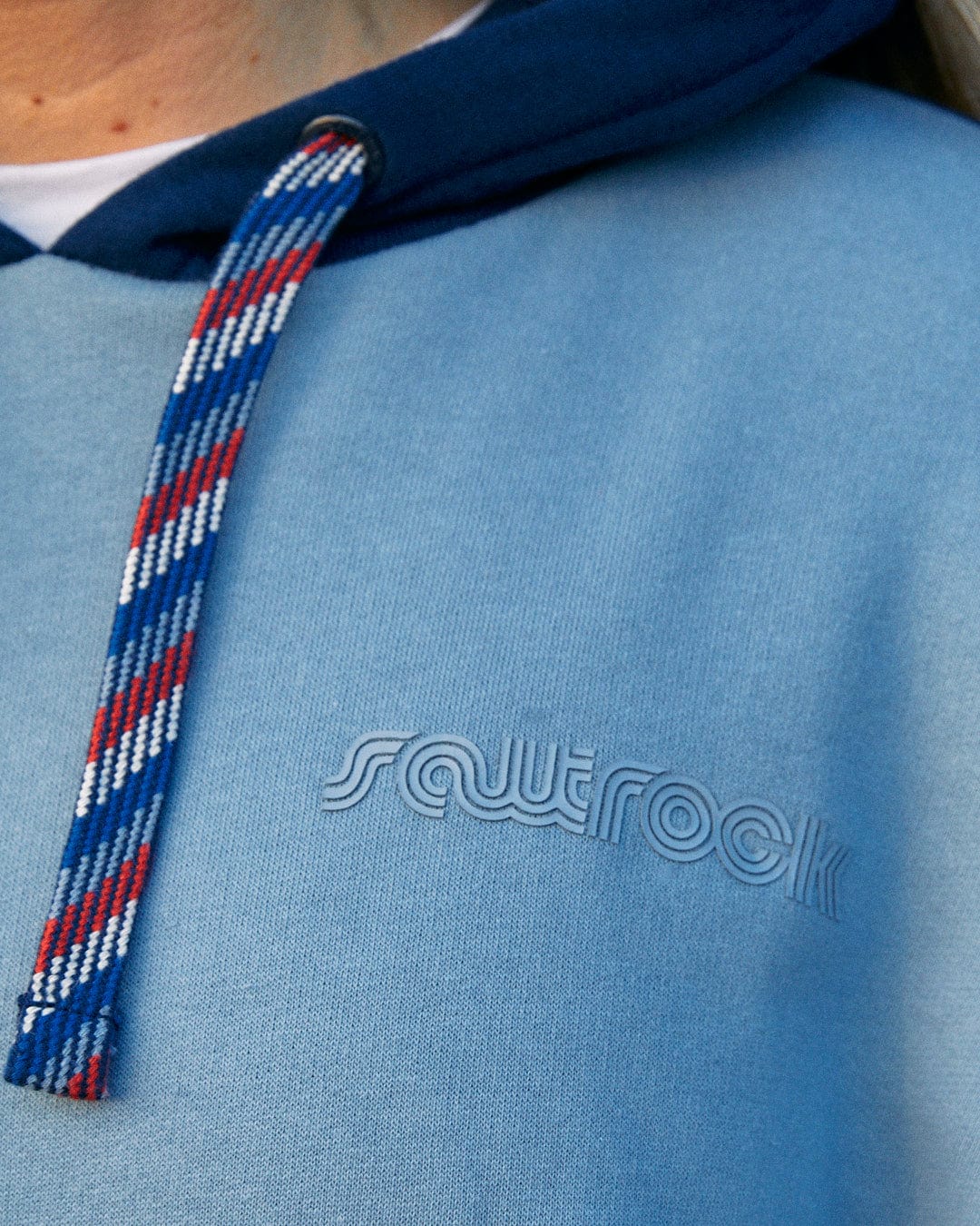 A woman wearing the Saltrock Anya - Womens Pop Hoodie - Blue with red, white and blue stripes featuring contrast paneling.