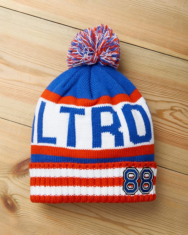 An Apres - Beanie - Blue with the word altrd on it, featuring Saltrock branding and a pom pom.