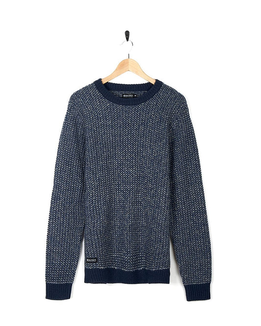 The Saltrock Arlen - Mens Crew Knit - Blue Sweater is delicately draped on a hanger. Ideal for cold weather conditions, this garment features Saltrock branding.