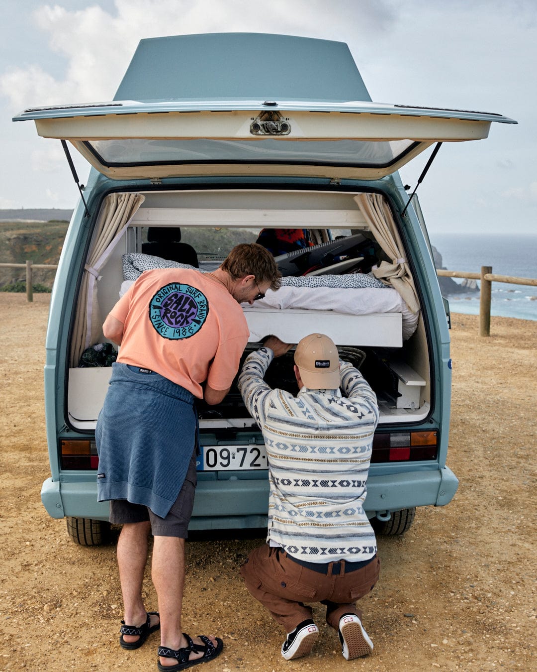 Two men are opening the trunk of a blue van made with Asher - Mens Jacquard Shirt - Cream by Saltrock, which is 100% Cotton.