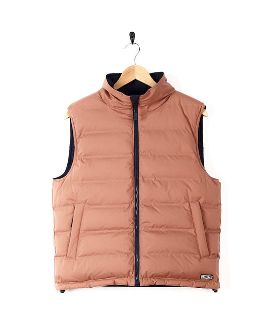 A reversible blue/pink women's Astra - Womens Reversible Padded Gilet - Blue/Pink jacket with a detachable hood, hanging on a hanger by Saltrock.