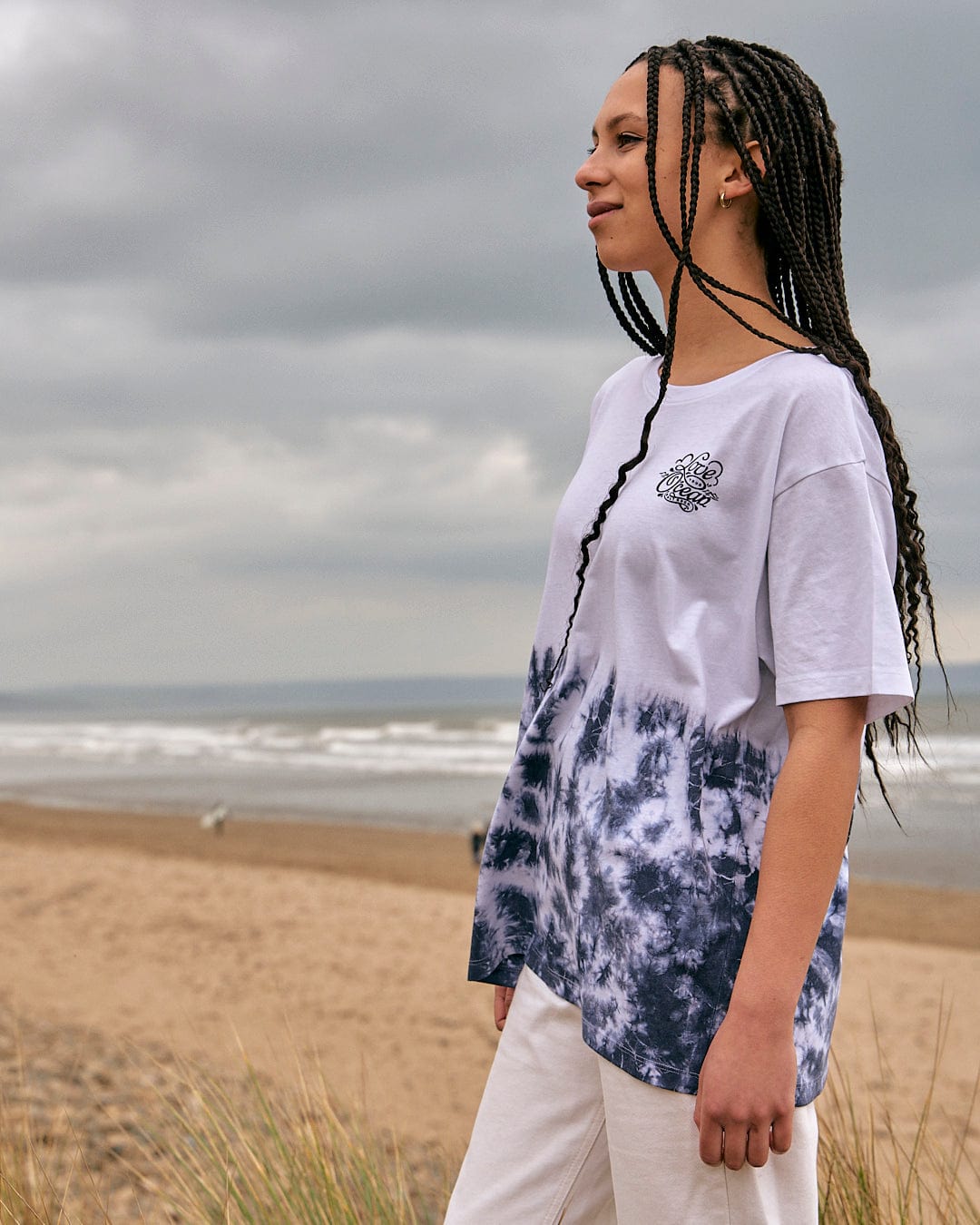 A woman standing on the beach wearing a Saltrock Astra - Womens Short Sleeve T-Shirt - White.