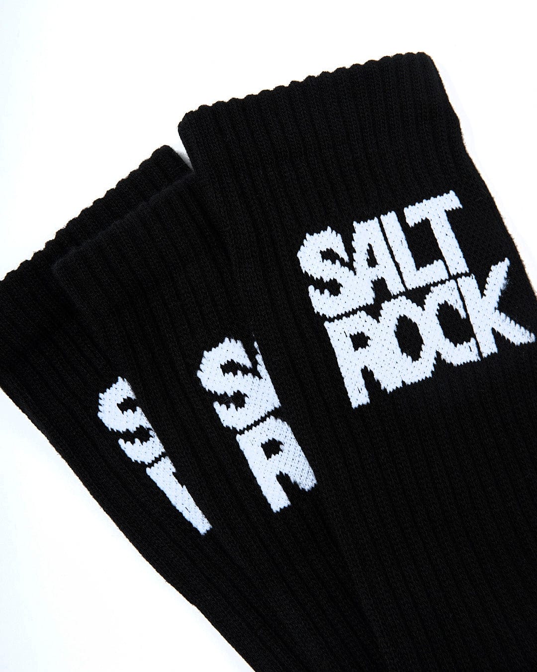 Close-up of three black mid calf length socks with the brand name "Saltrock" written in white on the cuffs, crafted from warm material. The product is called Athletic 3 Pack of Socks - Black.