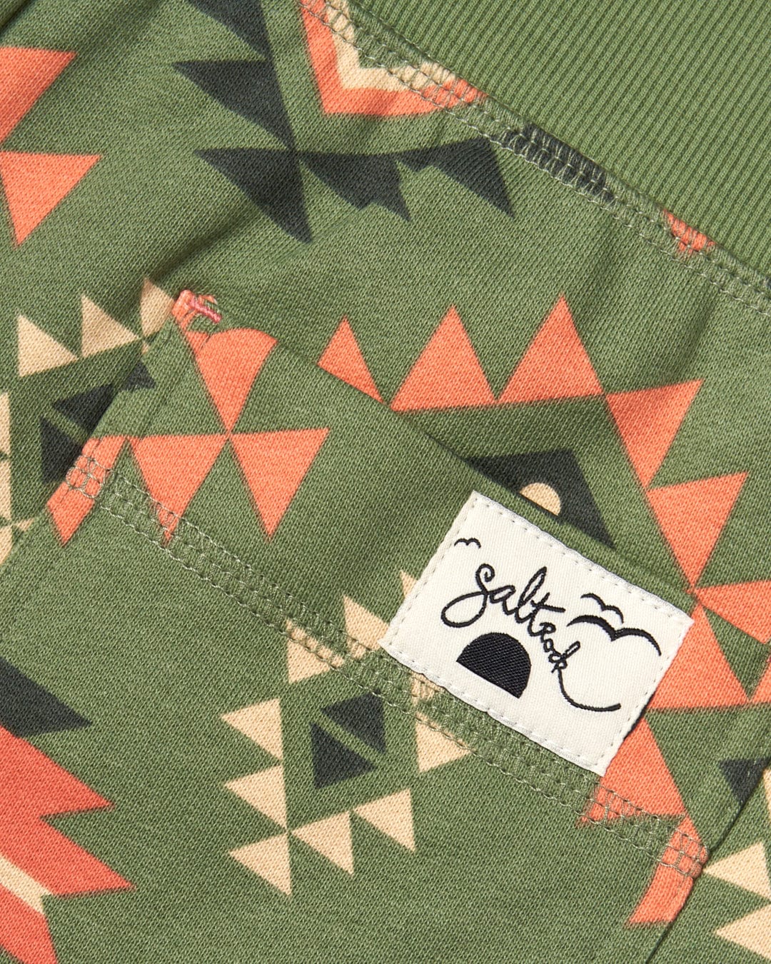 A pocket with an Aztec Santano - Womens Sweatshorts - Green/Orange print pattern on it by Saltrock.