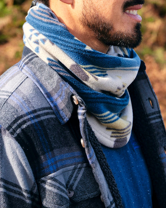 A stylish man in a plaid shirt wearing a Saltrock Aztec - Snood - Blue, perfect for winter days.