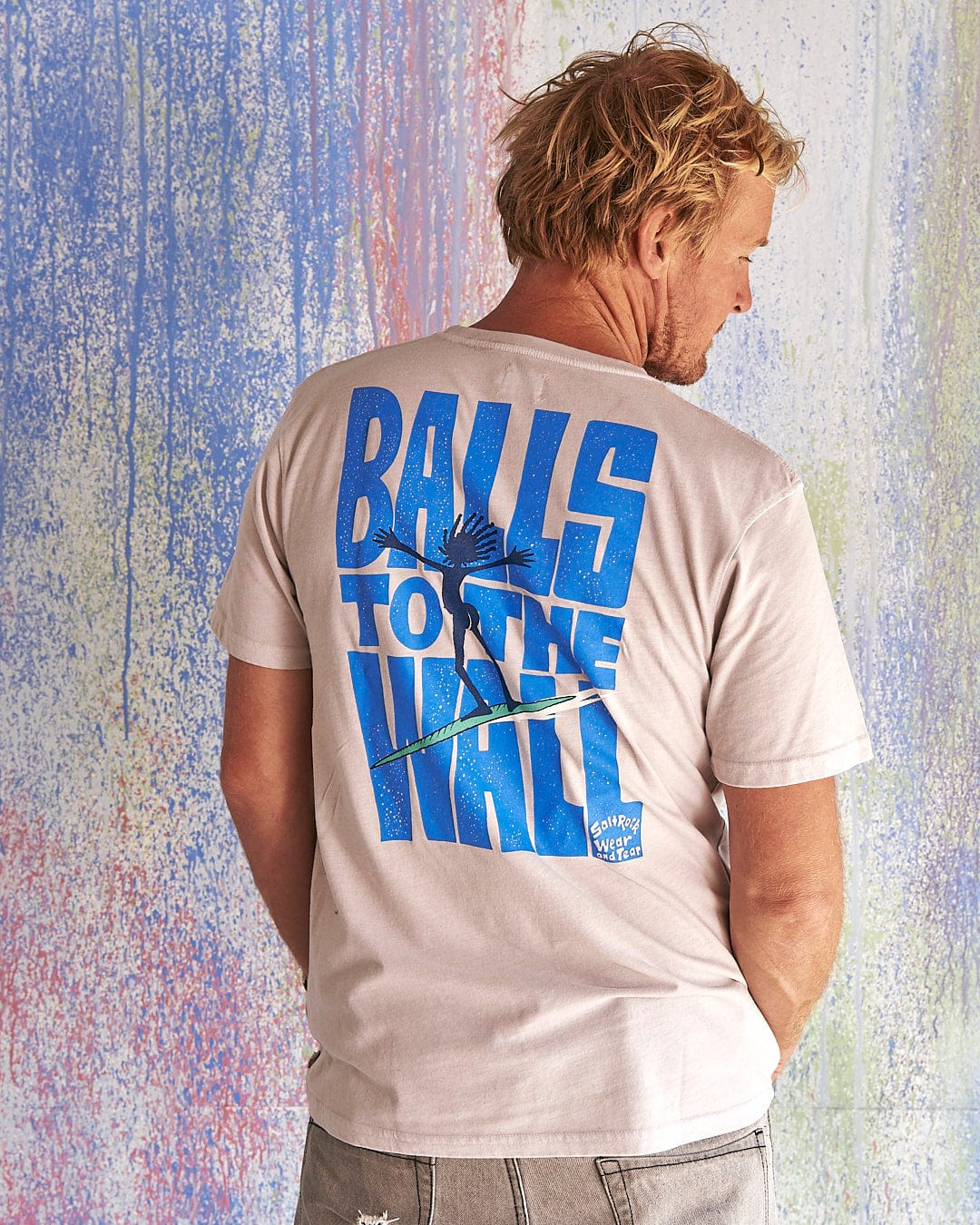 A man wearing a Saltrock t-shirt that says Balls To The Wall - Limited Edition 35 Years T-Shirt.