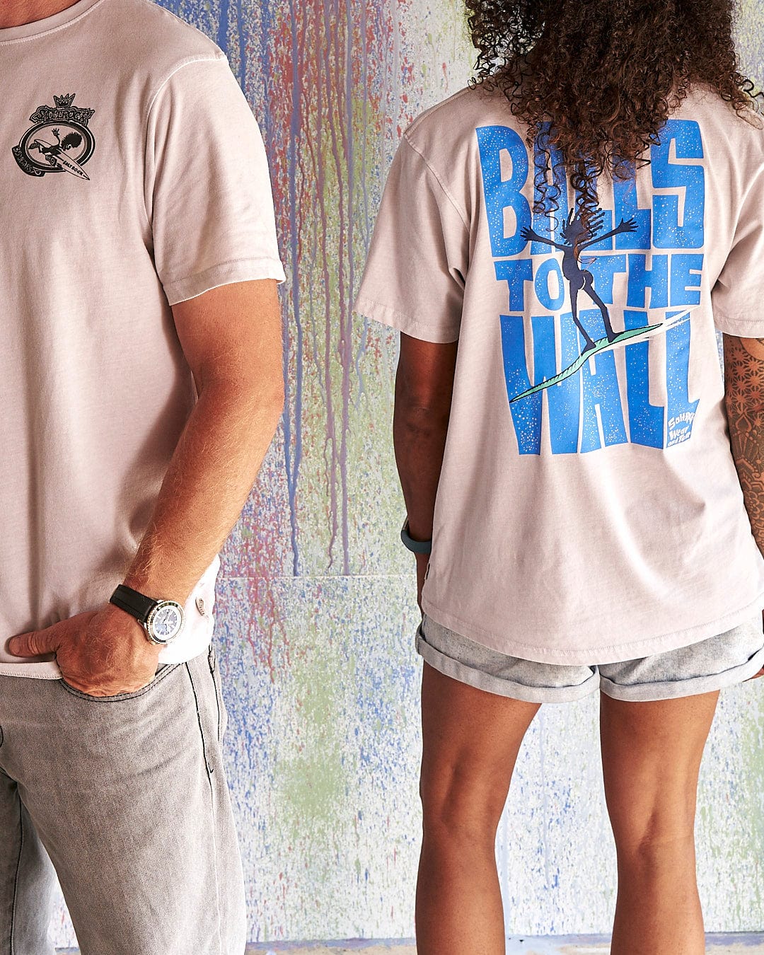 A man and woman standing next to each other wearing Saltrock's "Balls To The Wall - Limited Edition 35 Years T-Shirt".