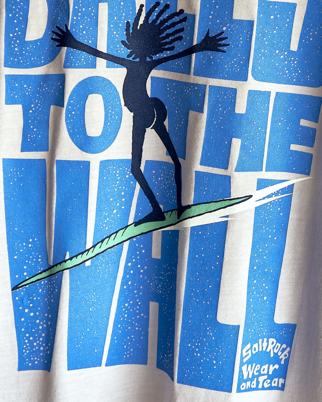A Saltrock "Balls To The Wall - Limited Edition 35 Years" t-shirt with a surfer on a surfboard.