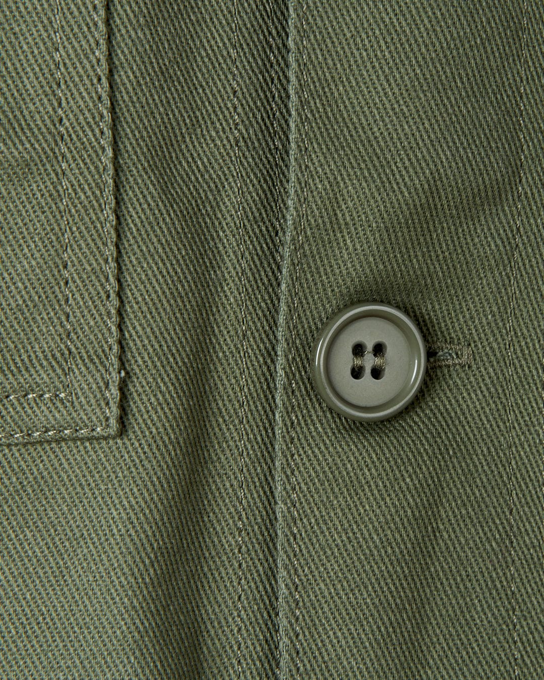A close up of a button on a Saltrock Barden - Womens Lightweight Utility Jacket in Dark Green.