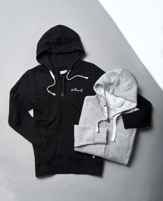 A black and grey Saltrock Velator Zip Hoodie and a white hoodie featuring Saltrock branding.