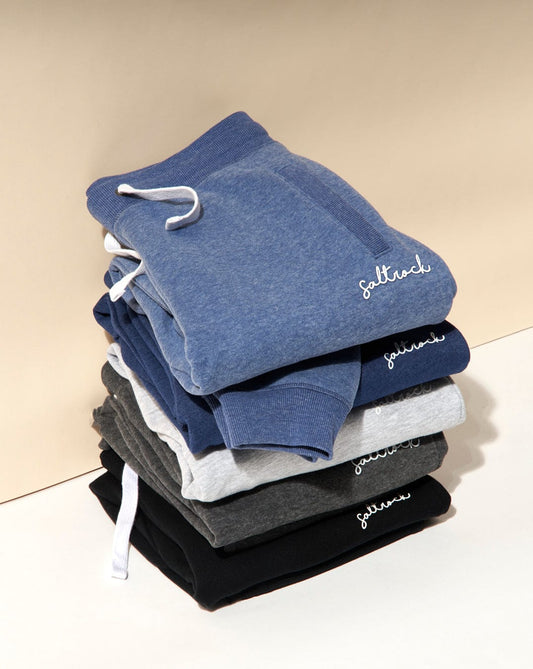 A stack of neatly folded Velator womens joggers in Blue Marl with Saltrock branding on a two-tone background.