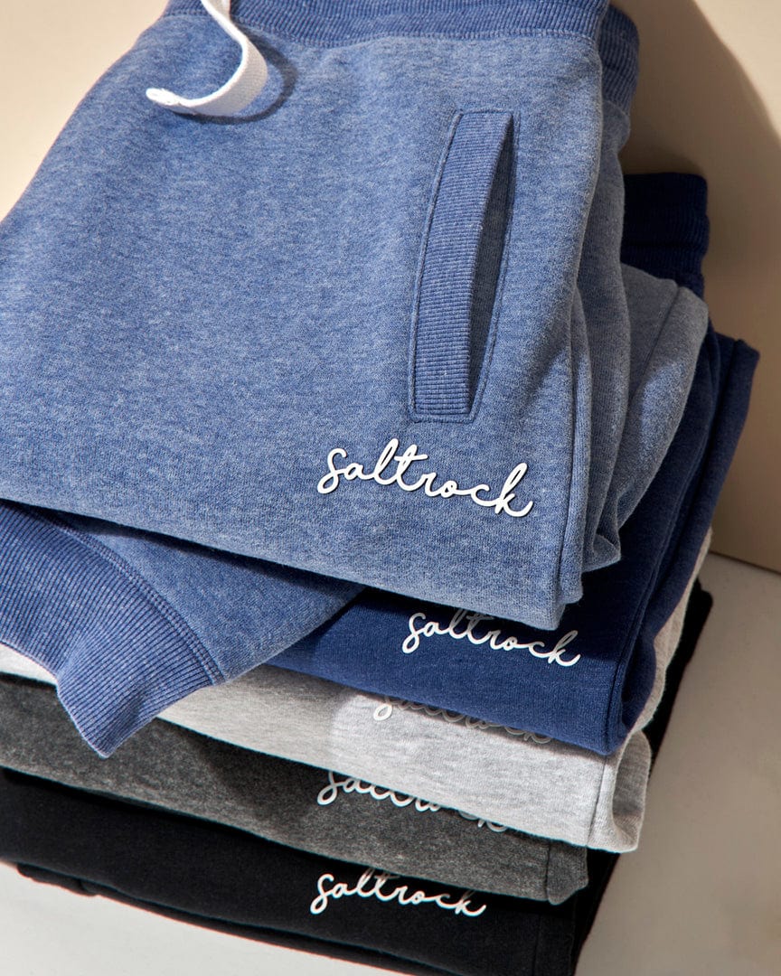 A stack of Saltrock Velator - Womens Jogger - Grey sweatpants with the word Stella embroidered on them.