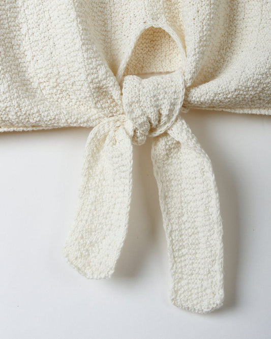 Cream textured knit scarf with a knot tied in the center, displayed on a plain background.