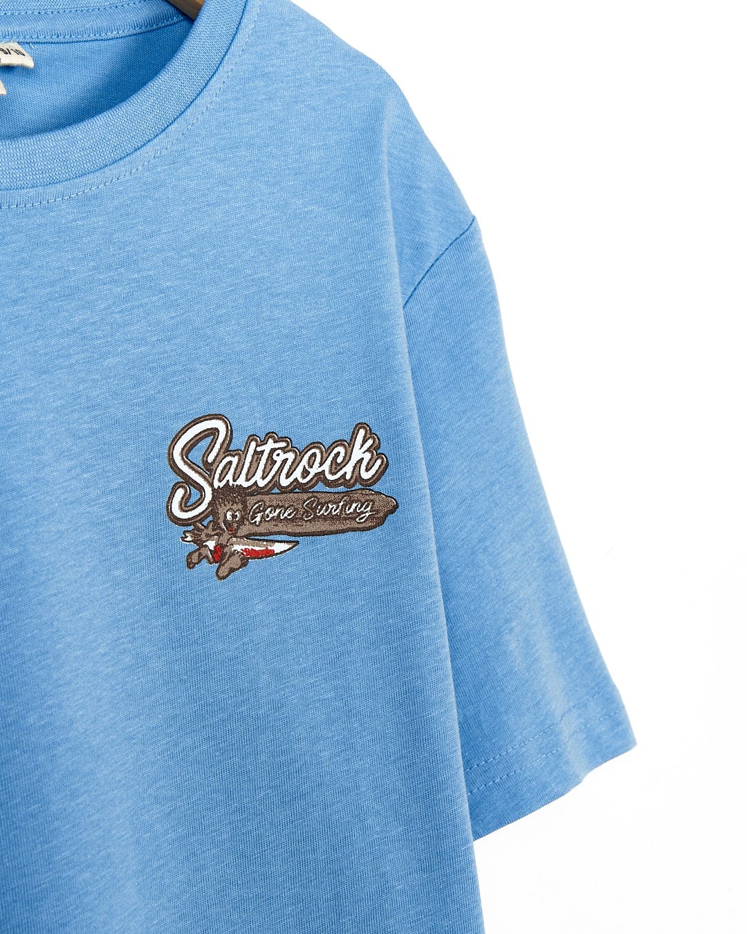 A Saltrock - Beach Signs Devon - Kids Short Sleeve T-Shirt - Light Blue with a brown logo on it.