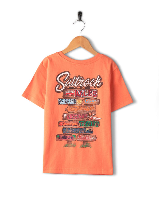 A cotton orange t-shirt with a Beach Signs Wales - Kids Short Sleeve T-Shirt - Orange branding sign on it.