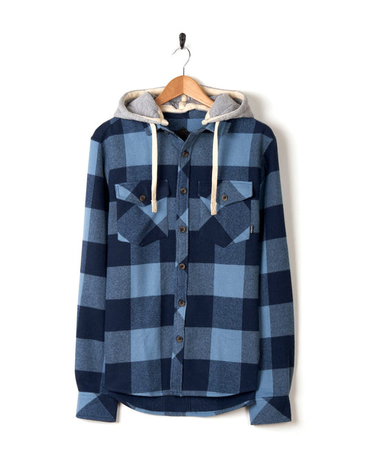 Beale - Mens Hooded Long Sleeve Shirt - Blue cotton flannel hoodie with a detachable hood, hanging on a white wall. (Saltrock)