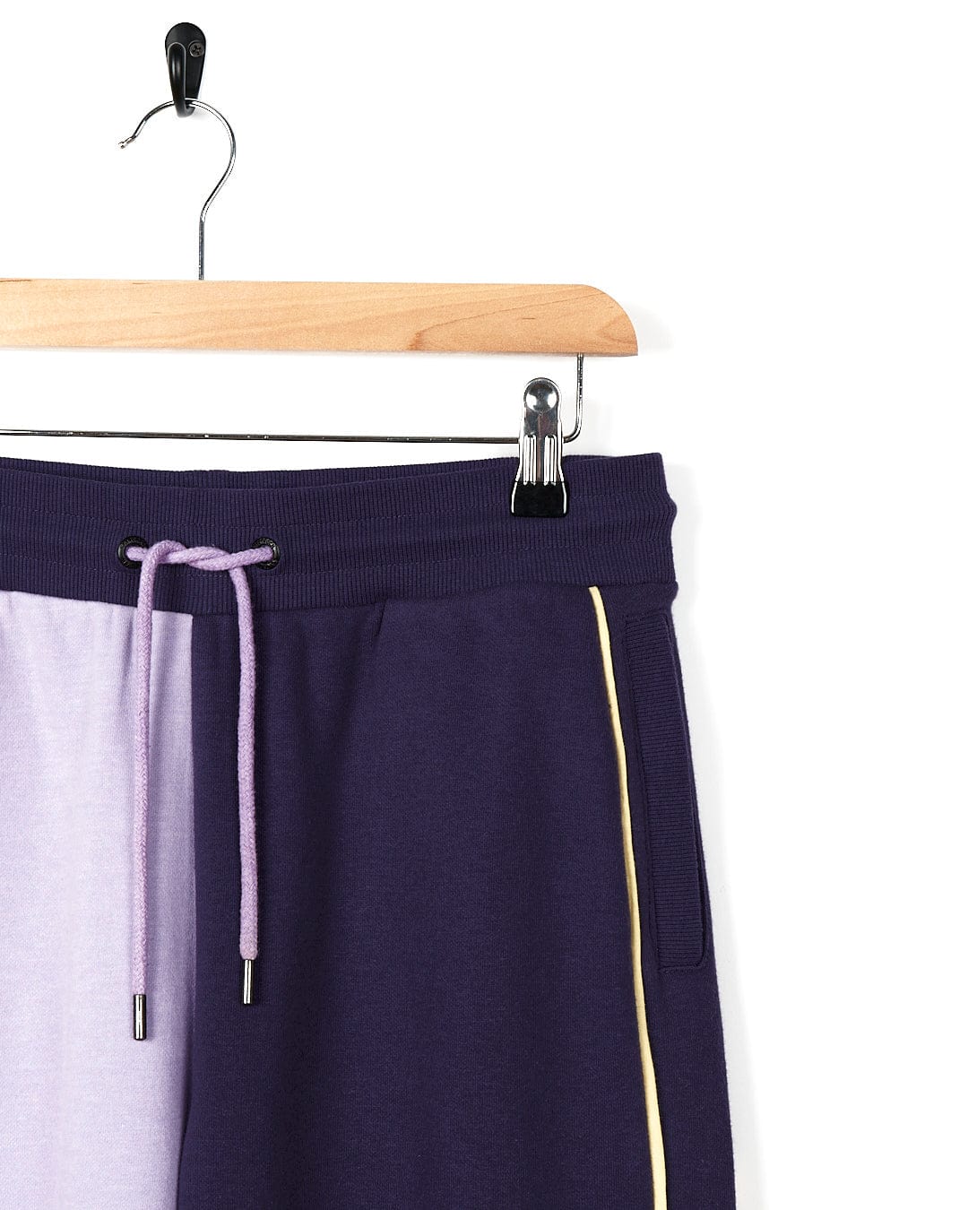 A pair of Betty - Womens Jogger - Light Purple sweat shorts by Saltrock hanging on a hanger.