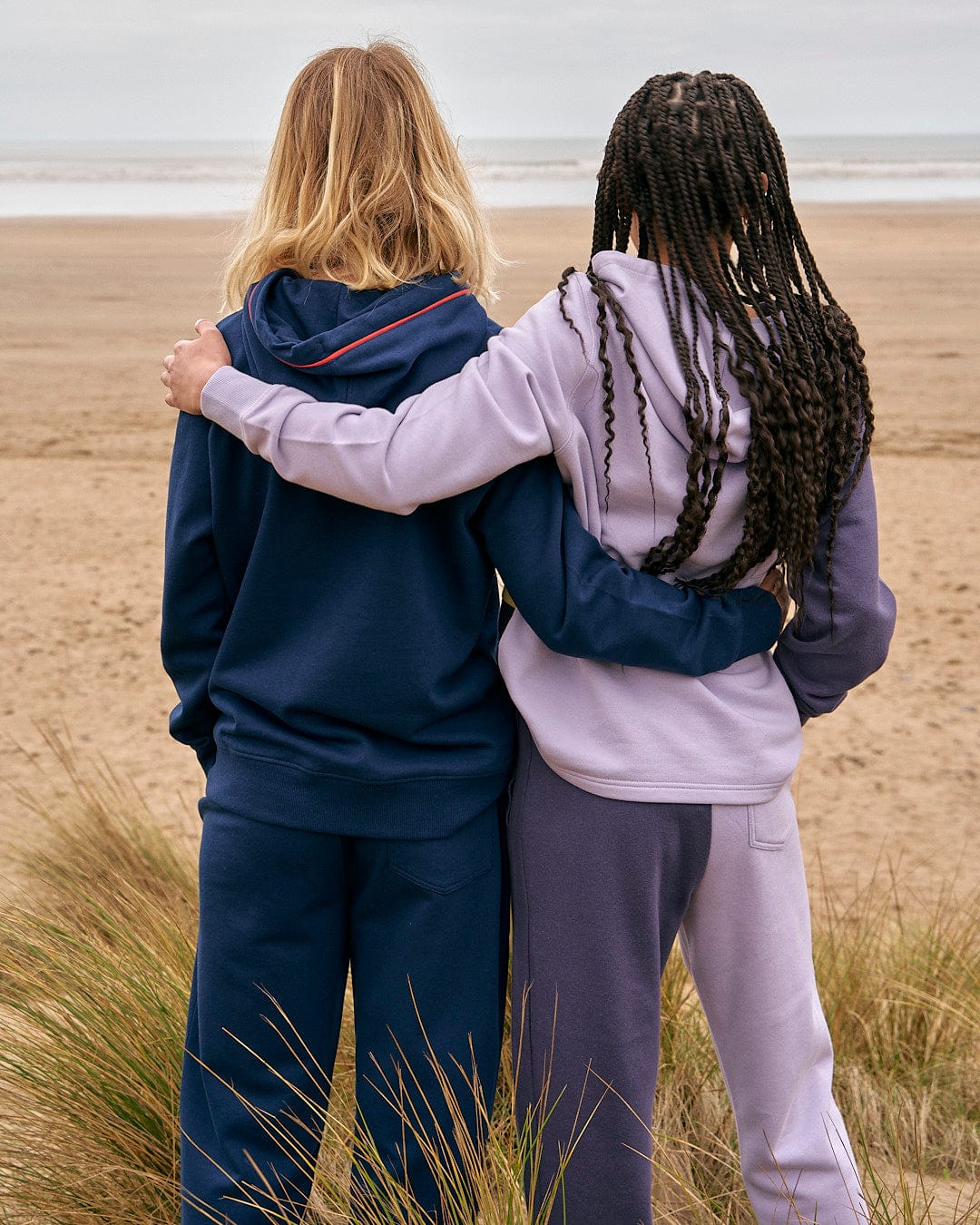 Two women hugging on the beach wearing Betty - Womens Jogger - Light Purple by Saltrock.