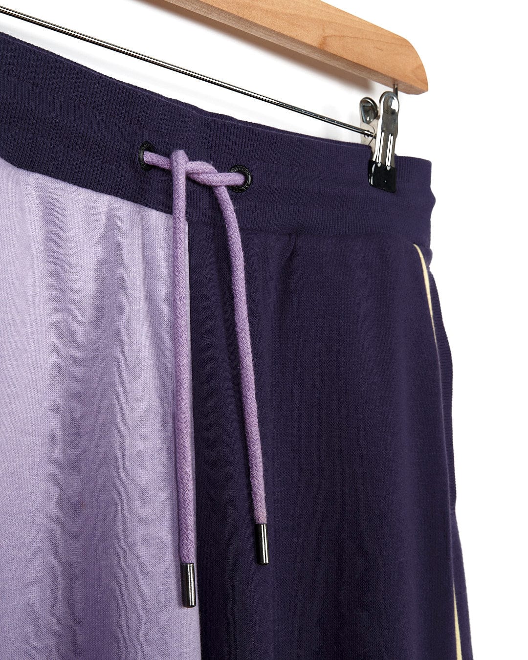 A pair of Betty - Womens Jogger - Light Purple sweatpants by Saltrock hanging on a hanger.