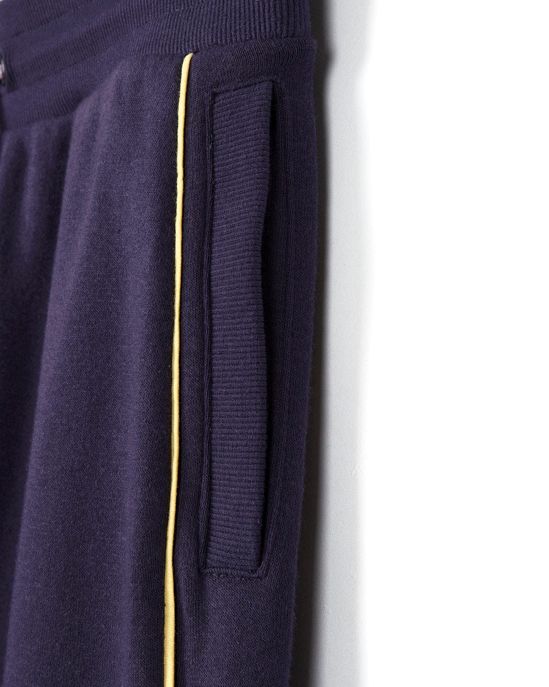 A pair of Saltrock sweatpants with a yellow stripe on the side.