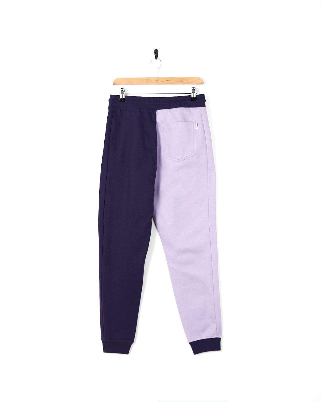 A pair of Betty - Womens Jogger - Light Purple sweatpants by Saltrock hanging on a hanger.
