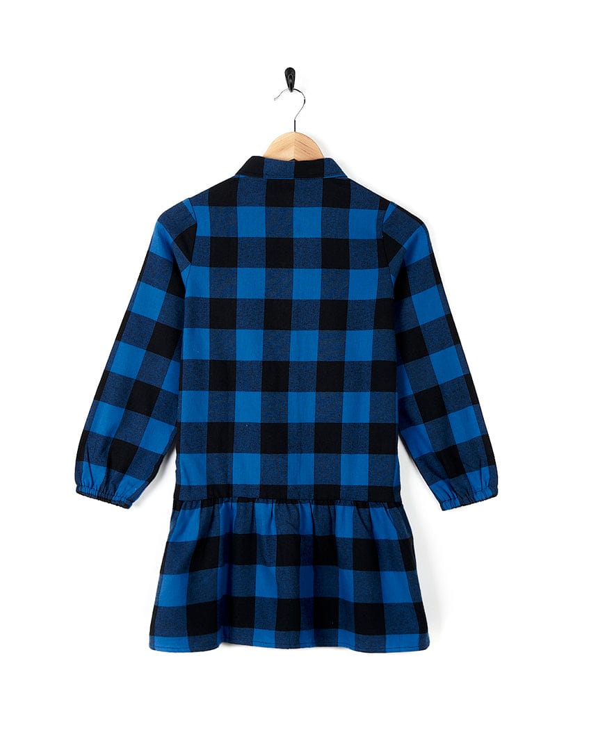 A 100% cotton Saltrock Birdie - Girls Check Shirt Dress - Blue hanging on a hanger.