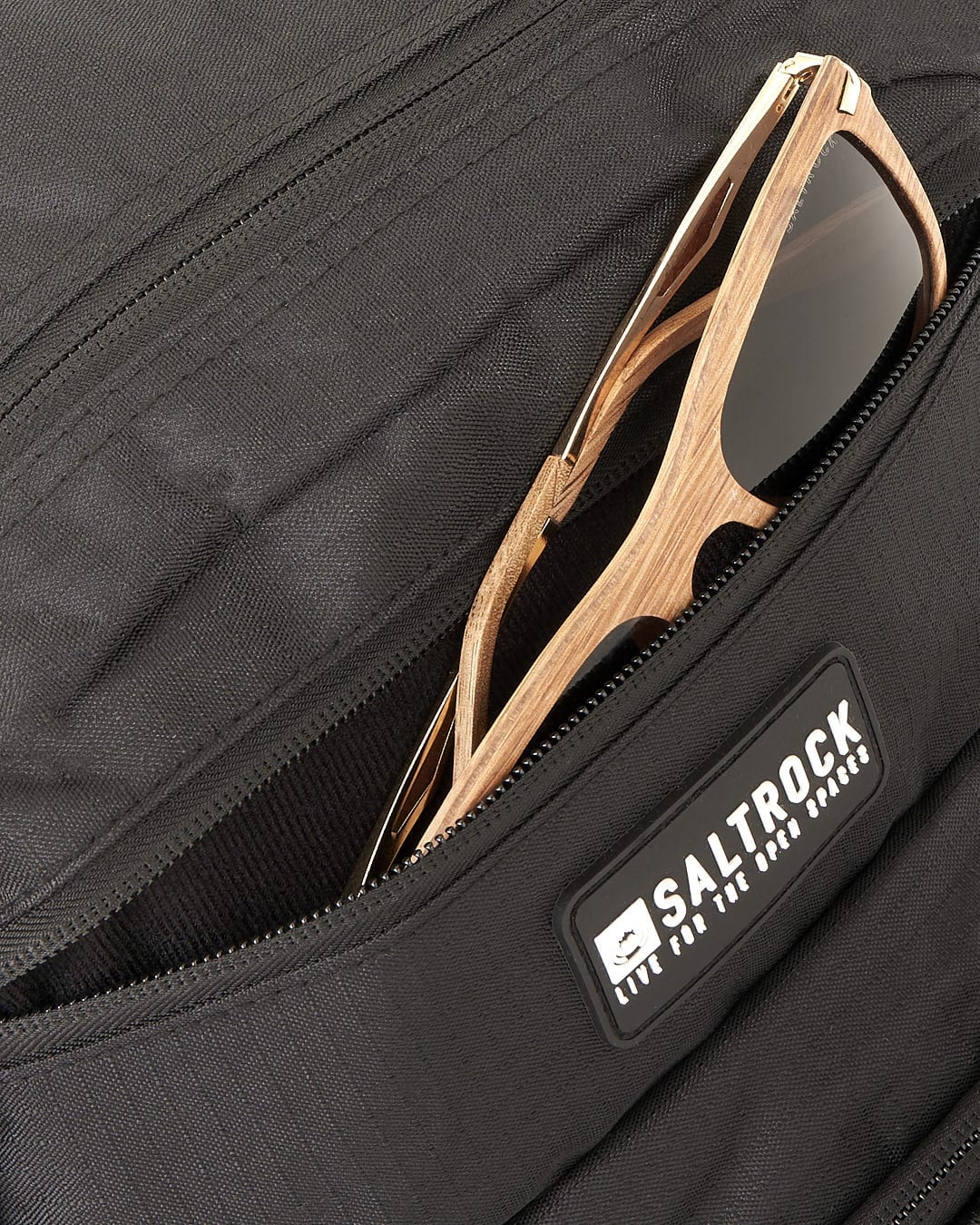 A Saltrock Boardwalk - Backpack - Black with a pair of sunglasses in it.