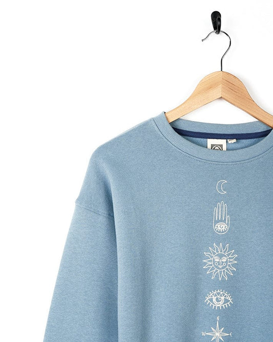 A Bodhi - Kids Crew Sweat - Light Blue with symbolic graphics featuring a sun, moon and stars designed by Saltrock branding.