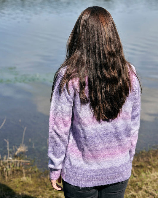 A woman is standing by a lake wearing a Saltrock - Bowden Womens Space Dye Crew Knit in Purple.