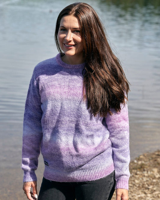 A woman wearing a Saltrock Bowden - Womens Space Dye Crew Knit - Purple sweater standing by a lake.