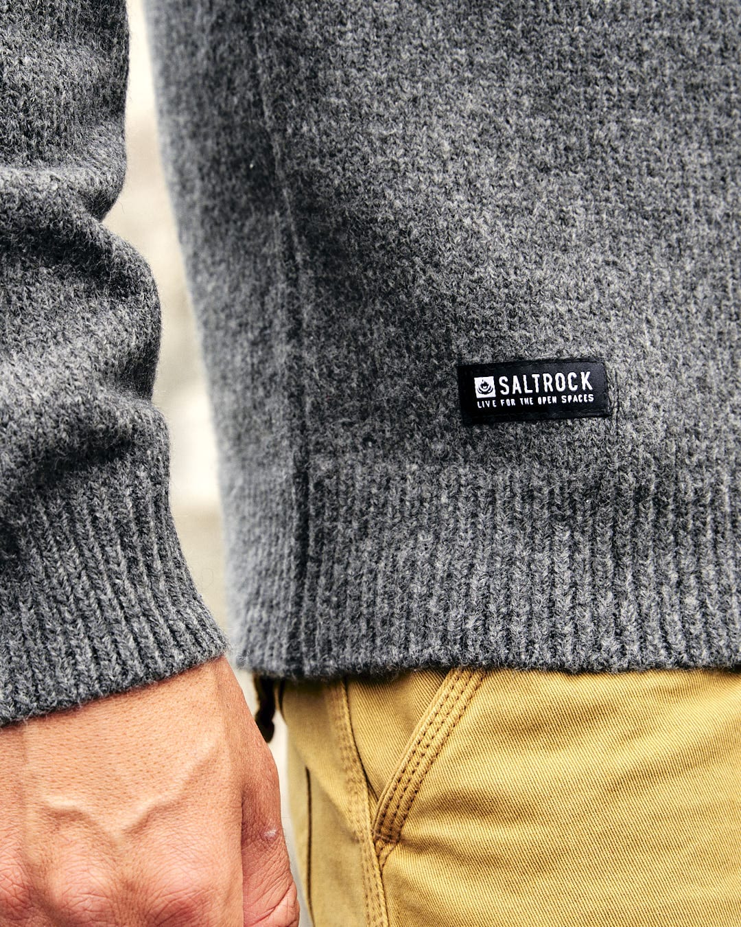 A man layering up in a Saltrock Bowen - Mens Knitted Crew - Dark Grey sweater.