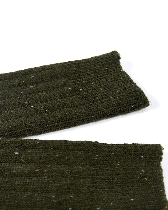 A pair of Cabin - Socks - Dark Green wool socks by Saltrock on a white surface.