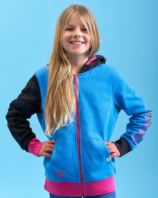 A young girl wearing a Saltrock Cara - Girls Zip Hoodie - Blue and pink leggings.