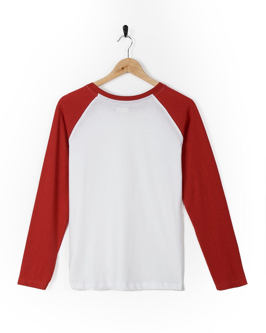 A Saltrock Carolina - Womens Long Sleeve Raglan T-Shirt - Red/White hanging on a wooden hanger.