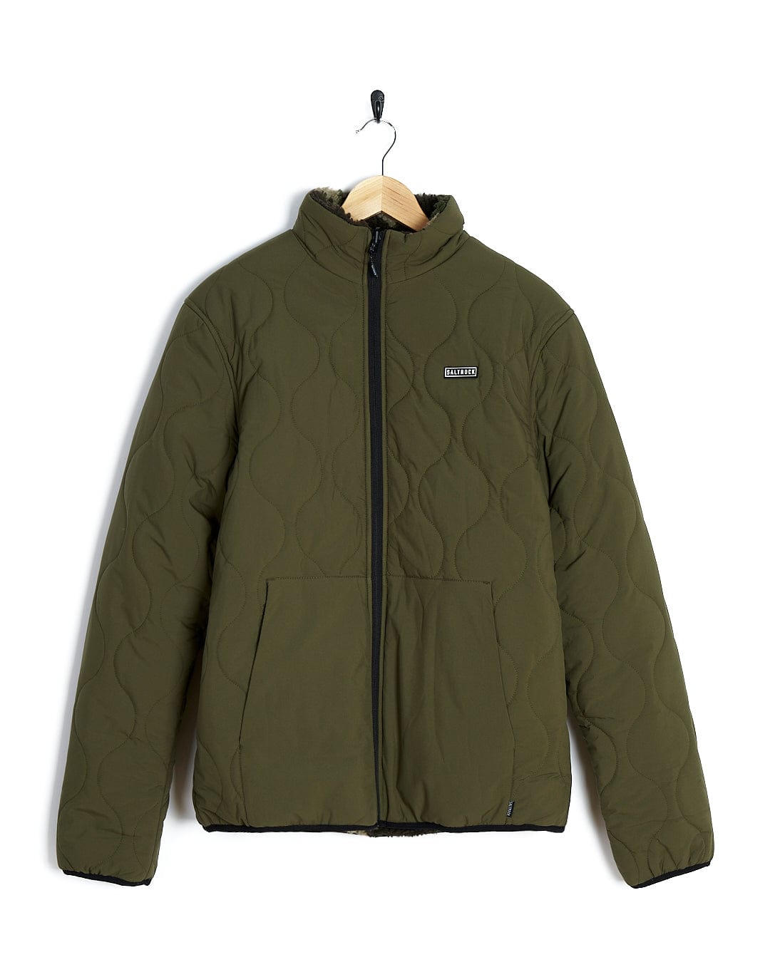 A Saltrock Cirrus - Quilted Reversible Jacket - Dark Green hanging on a hanger.