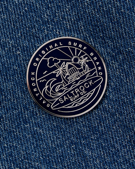 Round black and white Saltrock branded patch with silver graphics on navy denim fabric.
