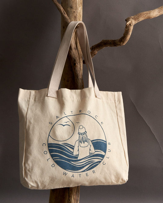 Cold Water Club - Recycled Shopper Bag - Cream tote bag with ocean-themed print and shoulder straps hanging on a wooden branch by Saltrock.