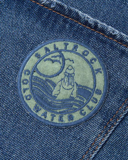 The pocket of the blue denim jacket features an embroidered logo of Cold Water Club - Patches - Green by Saltrock.
