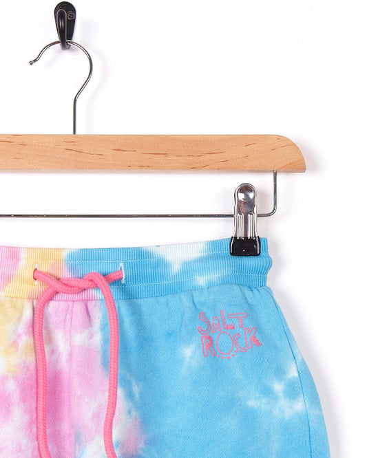 A Saltrock Coralia - Kids Tie Dye Sweat Short - Pink is hanging on a hanger.