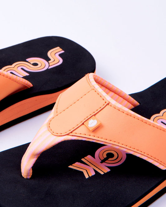 A pair of Saltrock Cora Retro - Womens Flip Flops in black and peach with the word "soul" written in a stylized font on the insole, positioned against a white background.