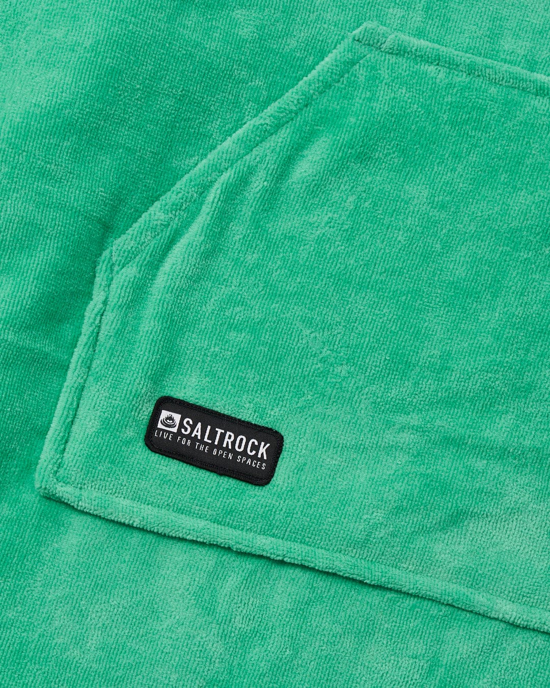 Close-up of a green absorbent cotton towelling Saltrock Corp Changing Towel - Green with a brand label.