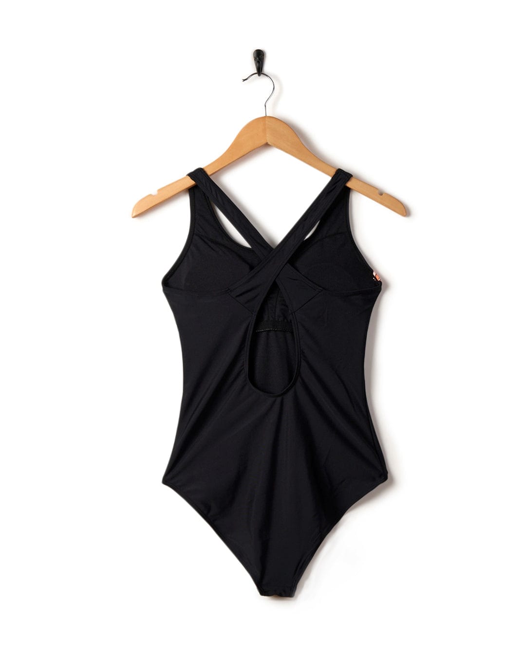 Corrine Retro - Recycled Womens Swimsuit - Black by Saltrock, with a crossed back design, hanging on a wooden hanger against a white background.