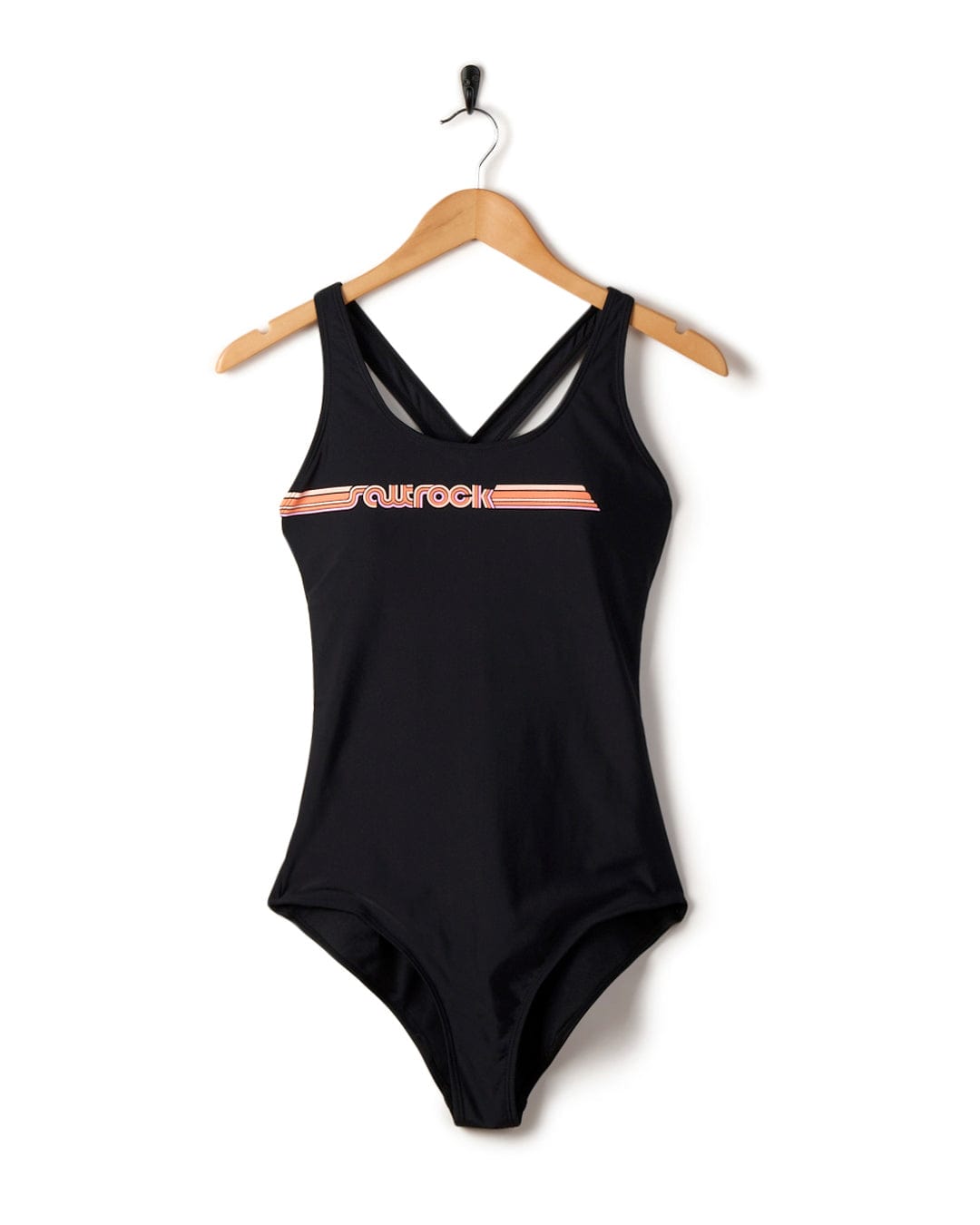 Corrine Retro swimsuit in black with white and pink trim, hanging on a wooden hanger against a white background.