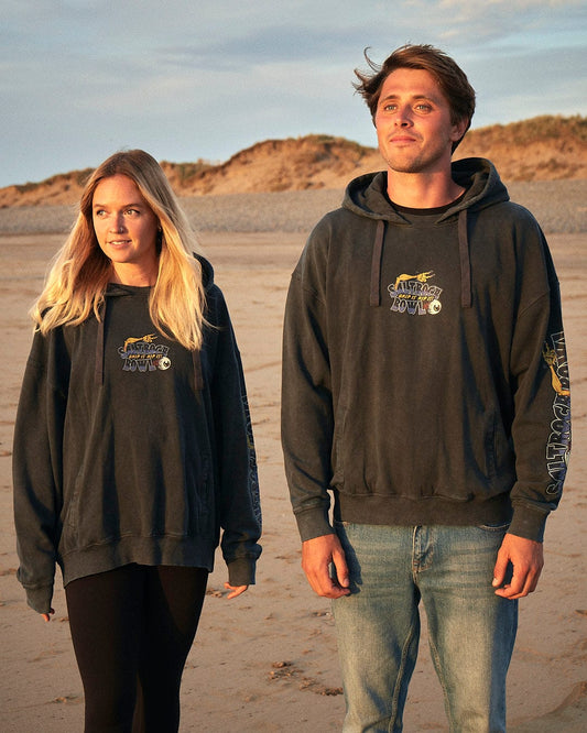 Two people standing on the beach wearing hoodies with Saltrock's Creeper Encore - Mens Pop Hoodie - Washed Black branding.