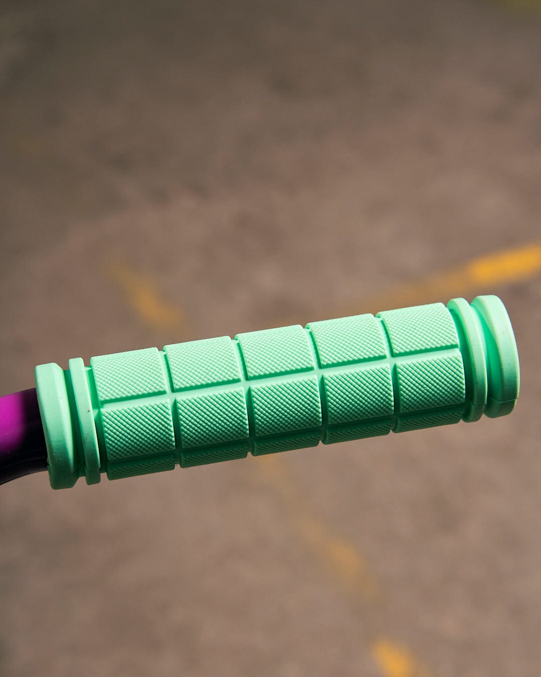 A close up of a Saltrock Creeper Stunt Scooter - Turquoise handlebar grip.