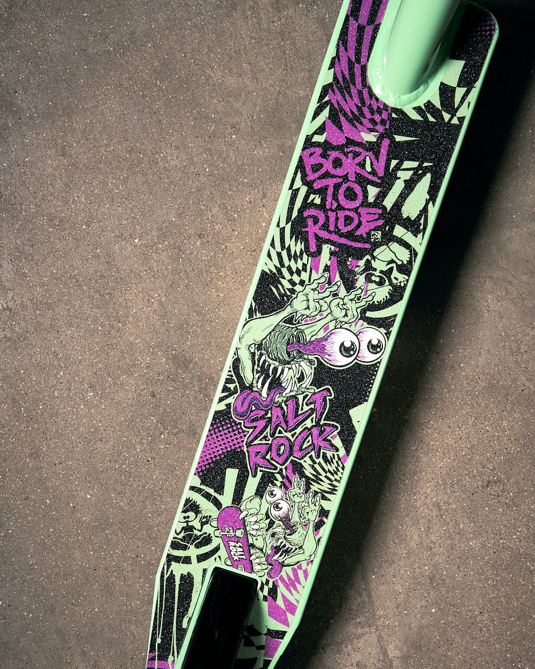 A green and purple Creeper Stunt Scooter - Turquoise by Saltrock with graffiti on it.